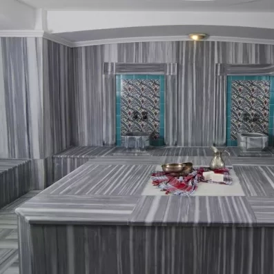 Un hammam traditionnel tout en marbre gris, agrémenté de vasques.
