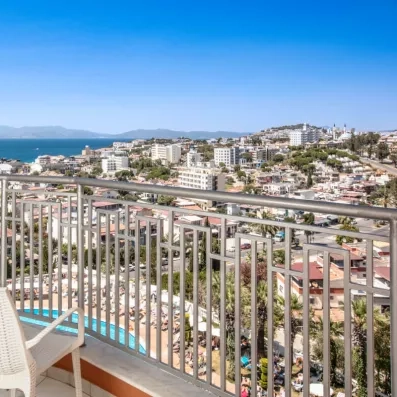 Vue panoramique depuis un balcon de l'hôtel surplombant la ville et la mer.