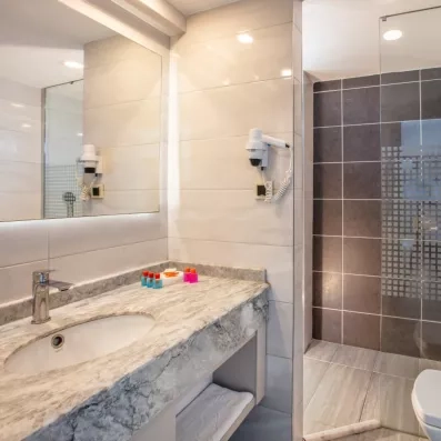 Vue d'ensemble d'une salle de bain lumineuse avec un lavabo en marbre.