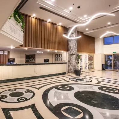 Une réception majestueuse avec un sol en marbre et un grand comptoir.