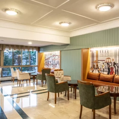 Un coin lounge avec des banquettes en cuir et des illustrations murales.