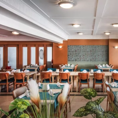Une salle à manger intérieure avec des tables nappées et des chaises en bois.