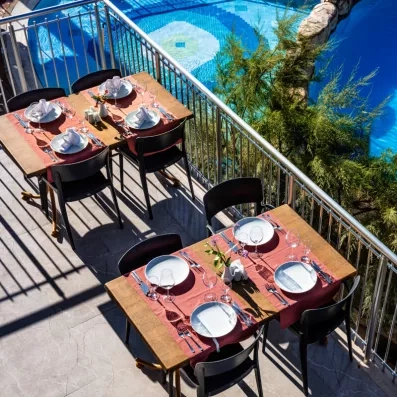 Une vue depuis la terrasse montrant des tables dressées surplombant une piscine.