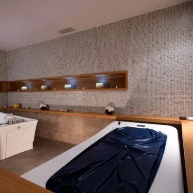 Un espace de soin spa moderne équipé d'une table d'hydromassage et d'un bain à remous.