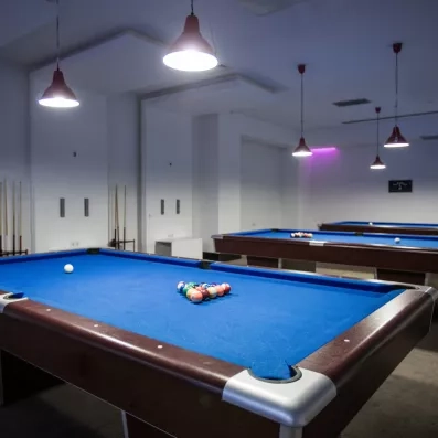 Un espace de jeux intérieur élégant proposant plusieurs tables de billard.