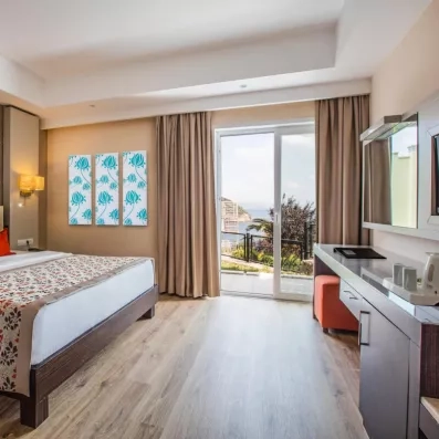 Une perspective de la chambre avec un lit double, mettant en avant son coin bureau.