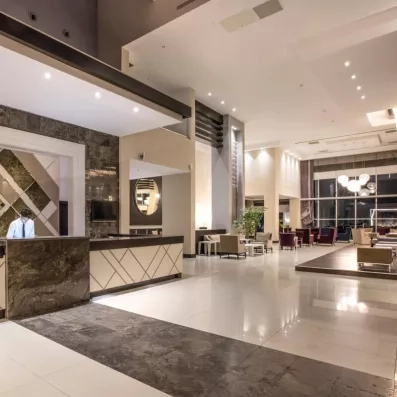 Une réception d'hôtel, mettant en avant des comptoirs en marbre sombre.