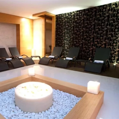 Une salle de relaxation zen dotée de chaises longues confortables et de bougies.