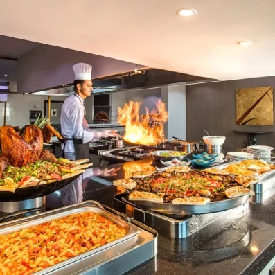 Un chef cuisinier faisant une démonstration en préparant des plats chauds devant les clients.