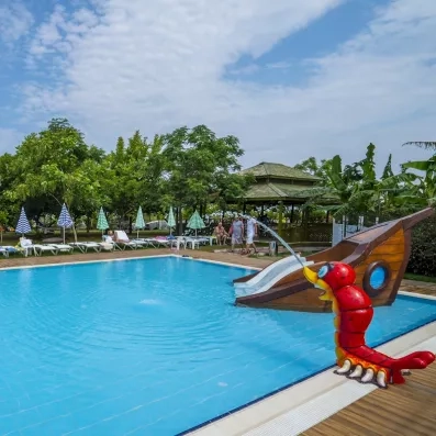 Un bassin pour enfants ludique équipé d'un petit toboggan en forme de bateau.