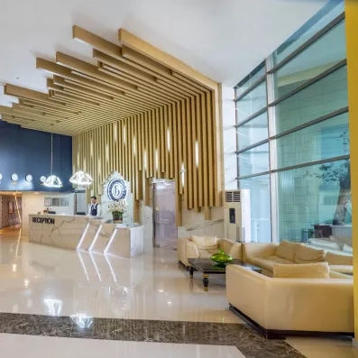 Un hall de réception élégant, avec un comptoir en marbre et des décorations murales.