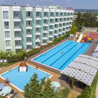 Un espace de loisirs extérieur avec une grande piscine, un bassin pour enfants.