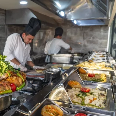 Les chefs s'activent en cuisine pour préparer un buffet généreux de spécialités.