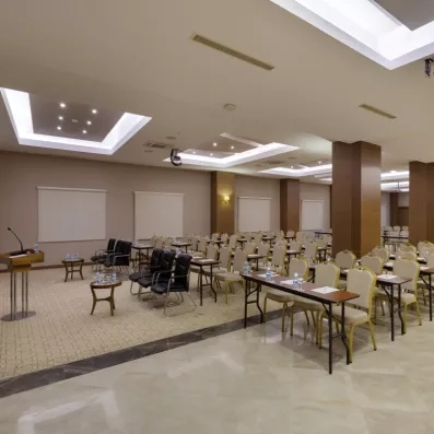 Une salle de conférence spacieuse, aménagée avec de nombreuses tables et chaises.