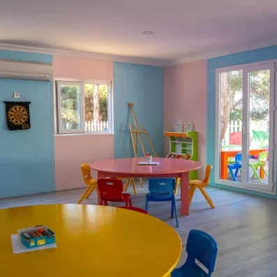 Un club pour enfants avec des tables d'activités et du matériel de dessin.