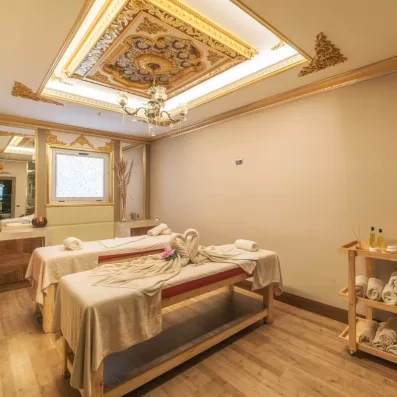 Une cabine de massage luxueuse avec deux tables prêtes pour un soin en duo.