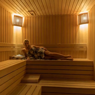 Vue de l'intérieur d'un sauna en bois chaleureux, ou une personne se détend.
