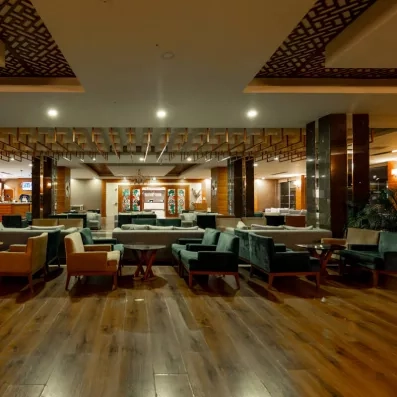 Un vaste espace de repos intérieur avec de nombreux canapés en velours.