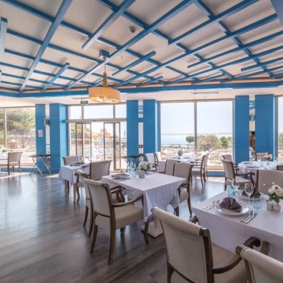 Un restaurant moderne au bord de la mer dispose de tables nappées.