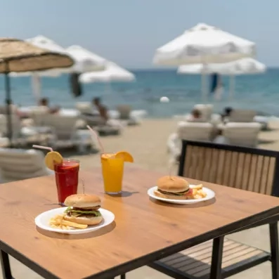 Deux convives profitent d'un déjeuner sur une terrasse ensoleillée face à la mer.