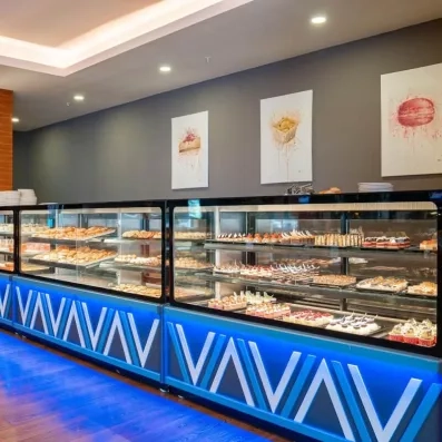 Une élégante pâtisserie en libre-service, sous un éclairage néon bleu.