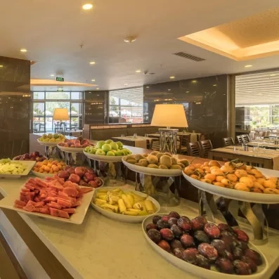 Un buffet d'hôtel chic présente une abondance de fruits frais bien rangés sur un comptoir en marbre.