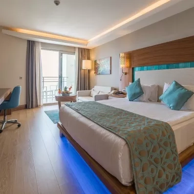 La perspective de la chambre depuis le lit, s'ouvrant sur une baie vitrée et un petit espace bureau.