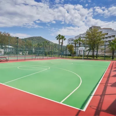 Un terrain de sport polyvalent extérieur, pour la pratique du basket-ball ou du tennis.