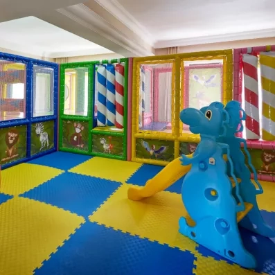 Un espace de jeux intérieur avec un petit toboggan en forme d'éléphant.