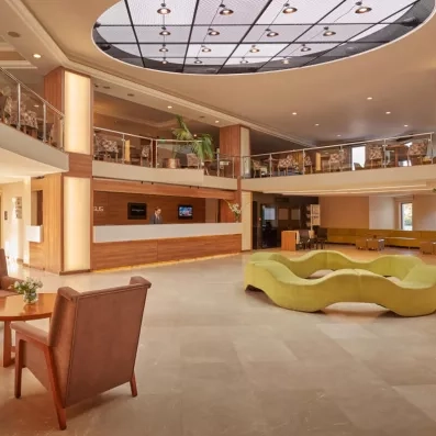 Un vaste hall d'accueil lumineux, avec de grands canapés et d'un puits de lumière.