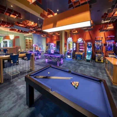 Bowling, jeux d'arcade, table de billard, luminaires carrés de couleur orange, chaises hautes bleues