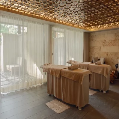 deux tables de massage devant une vitre lumineuse, ambiance zen, salle de massage