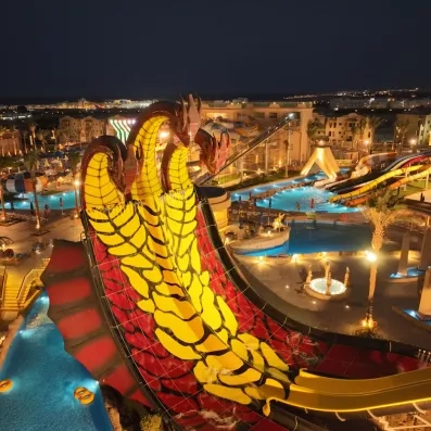 Éclairage nocturne du parc aquatique et du toboggan serpent au Mondi Club Stella Garden, Égypte.