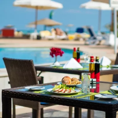 Espace restauration extérieur convivial près de la piscine Oasis au Mövenpick Resort & Spa El Gouna.