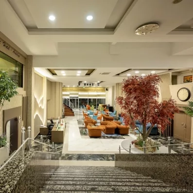 grand hall d'entrée avec escaliers et fauteuils