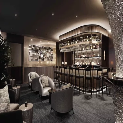 Bar d'argent, murs en facettes, fauteuils couleur argent, grande plante, tabourets de bar noirs, bouteilles, miroir