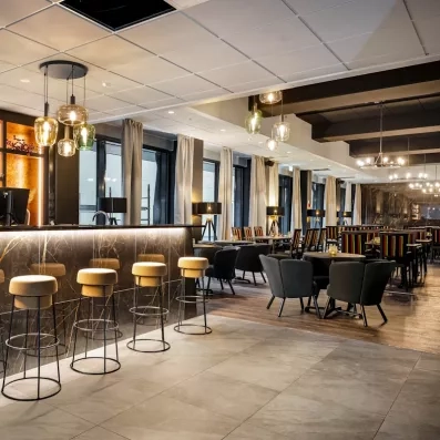 Bar lounge élégant et espace petit-déjeuner avec tabourets hauts à l'Hôtel Sodankylä.