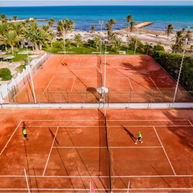 Terrains de tennis en terre battue avec vue panoramique sur la mer au complexe Palm Azur.