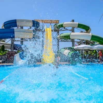 Vue d'une piscine extérieure avec différents toboggans aquatiques.