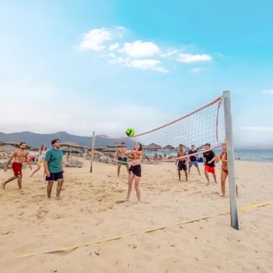 Un groupe de jeunes profite d'une partie de volleyball sur une plage ensoleillée.