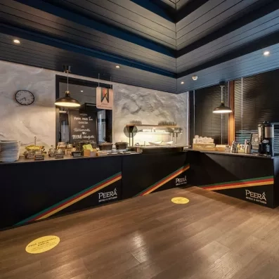 Buffet du petit-déjeuner de l'Hôtel Sodankylä présentant des produits locaux dans une salle de restauration au design nordique moderne.