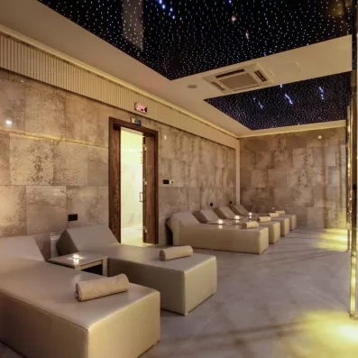 Une salle de relaxation élégante avec des chaises longues confortables sous un plafond scintillant.