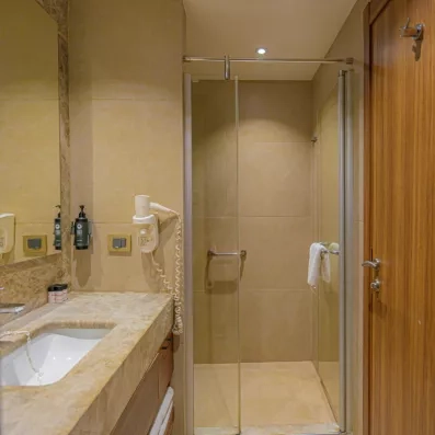 Une douche à l'italienne vitré, avec un meuble vasque en pierre naturelle.