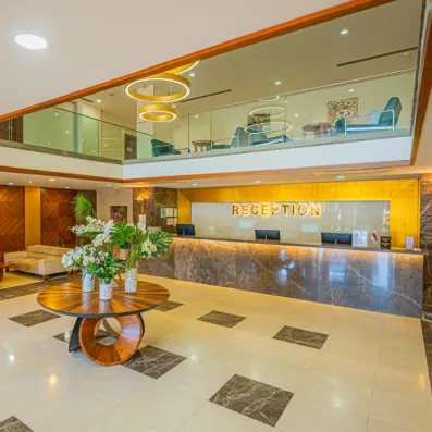 Une vue d'ensemble du hall montrant la réception et une mezzanine avec un coin salon.