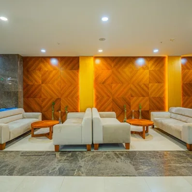 Un coin salon confortable avec des canapés disposés devant un mur décoré de boiseries.