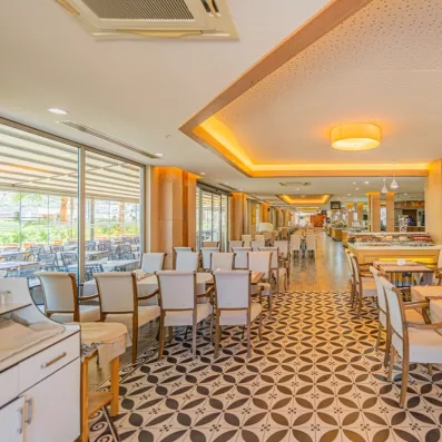 Une vue d'ensemble d'une grande salle de restauration avec des tables et fauteuils.