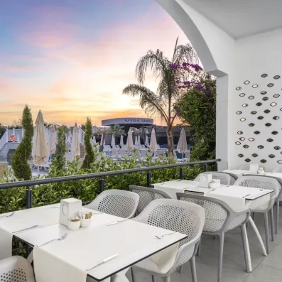 restaurant sur la terrasse vue sur la piscine au coucher du soleil