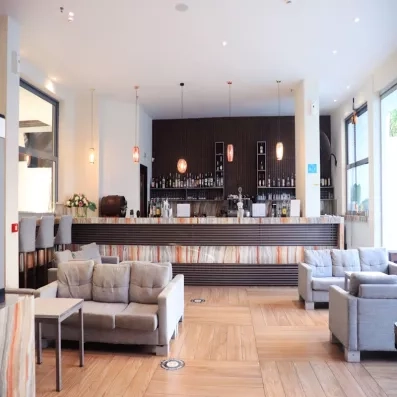 Bar de l'hôtel, avec comptoir et boissons décorées, salons et table basse