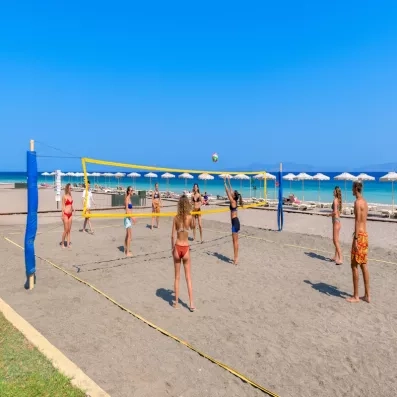 des touristes qui jouent aux volley ball au bord de la plage avec sable fin