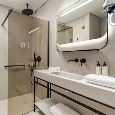 Salle de bain de la chambre avec baignoire, lavabo encastré, miroir, sèche cheveux, serviettes